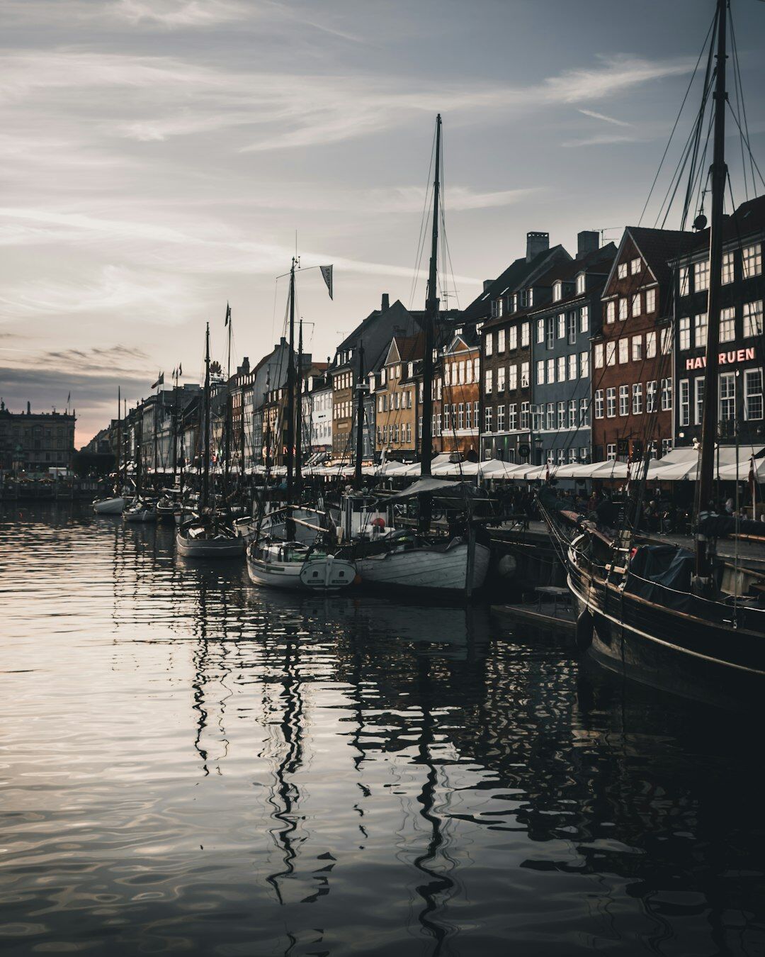Danish fisherman mending nets on a harbor quay at dawn