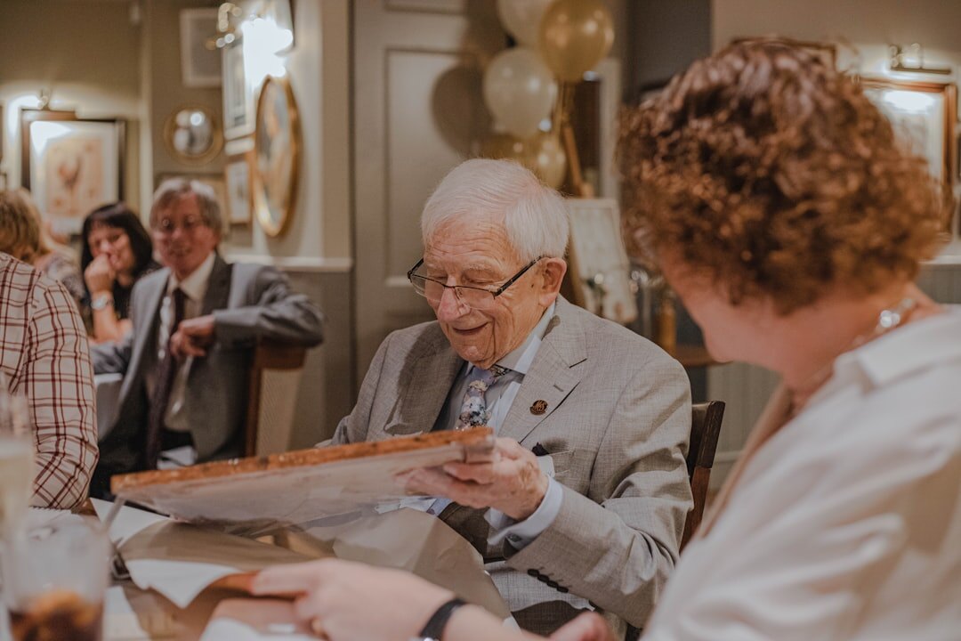 elderly man pointing at old photo